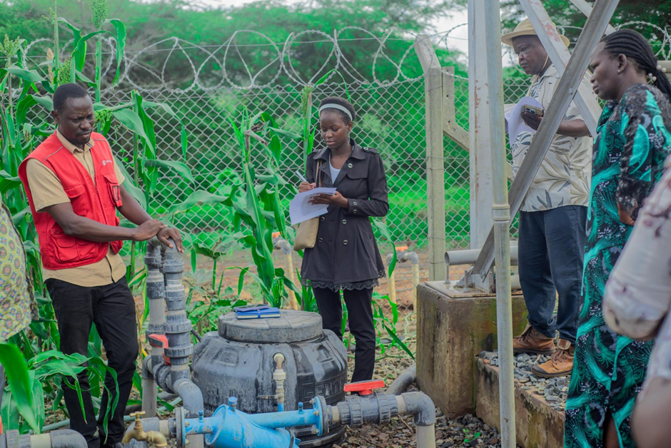 Save the Children Uganda staff shows the Irrigation water system to district leaders